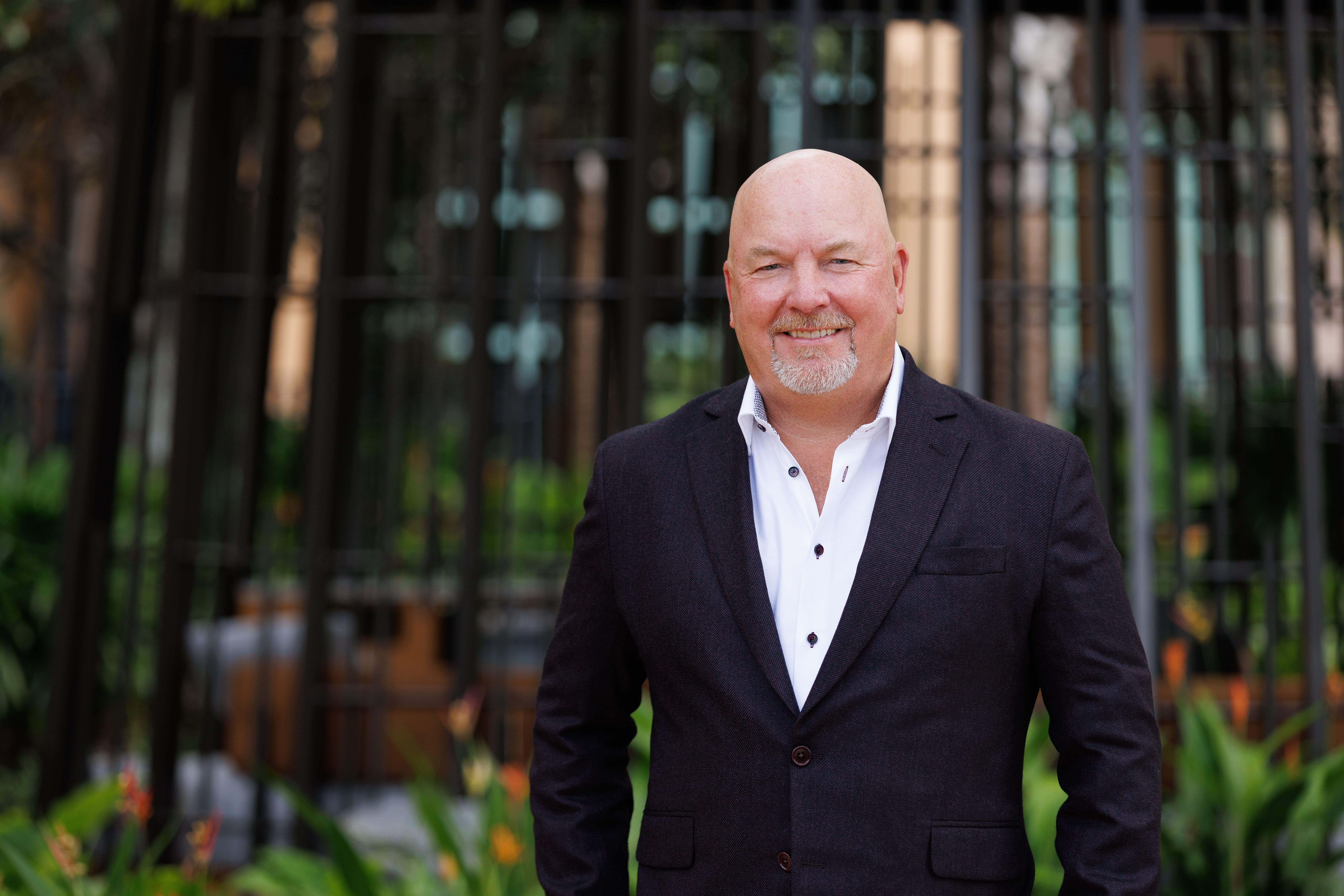 Portrait of a professional man with a garden background.